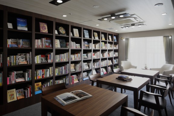 充実した蔵書を備えた図書室。木製テーブルと読書スペースが整備された共用部。