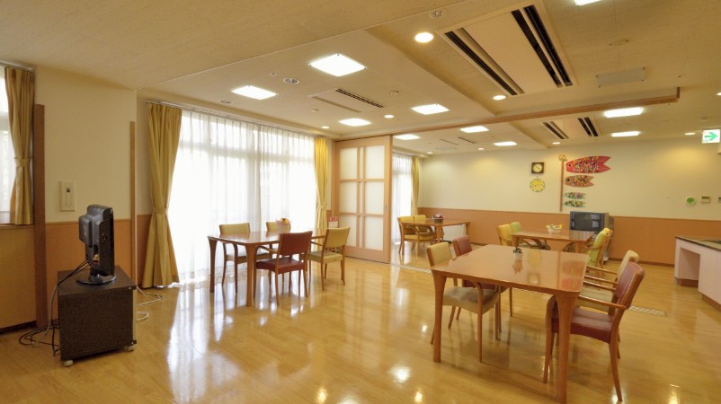 清潔感のある広々とした食堂。複数のテーブルと椅子が配置された明るい共有食事スペース。