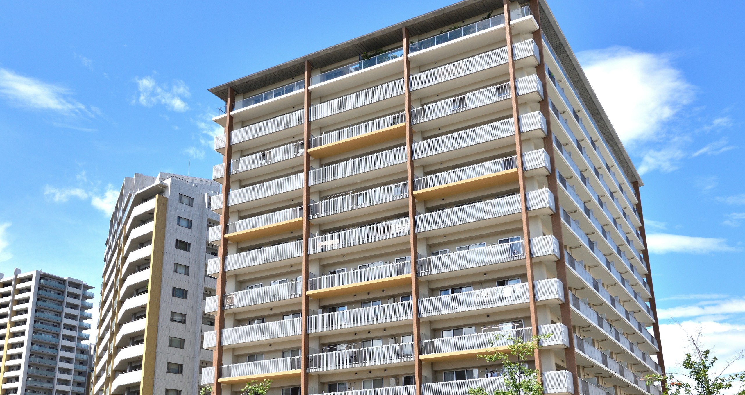 茶色と白のツートンカラーの介護施設の外観。複数階建てのバルコニー付き建物